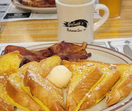 French toast dusted with powdered sugar and topped with butter, with bacon and a Galante’s coffee mug.